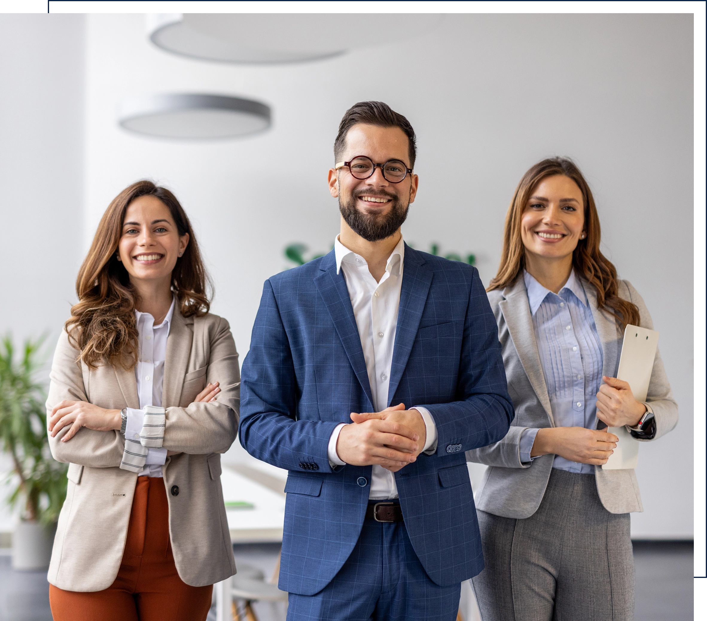 Three professionals smiling in a modern office.