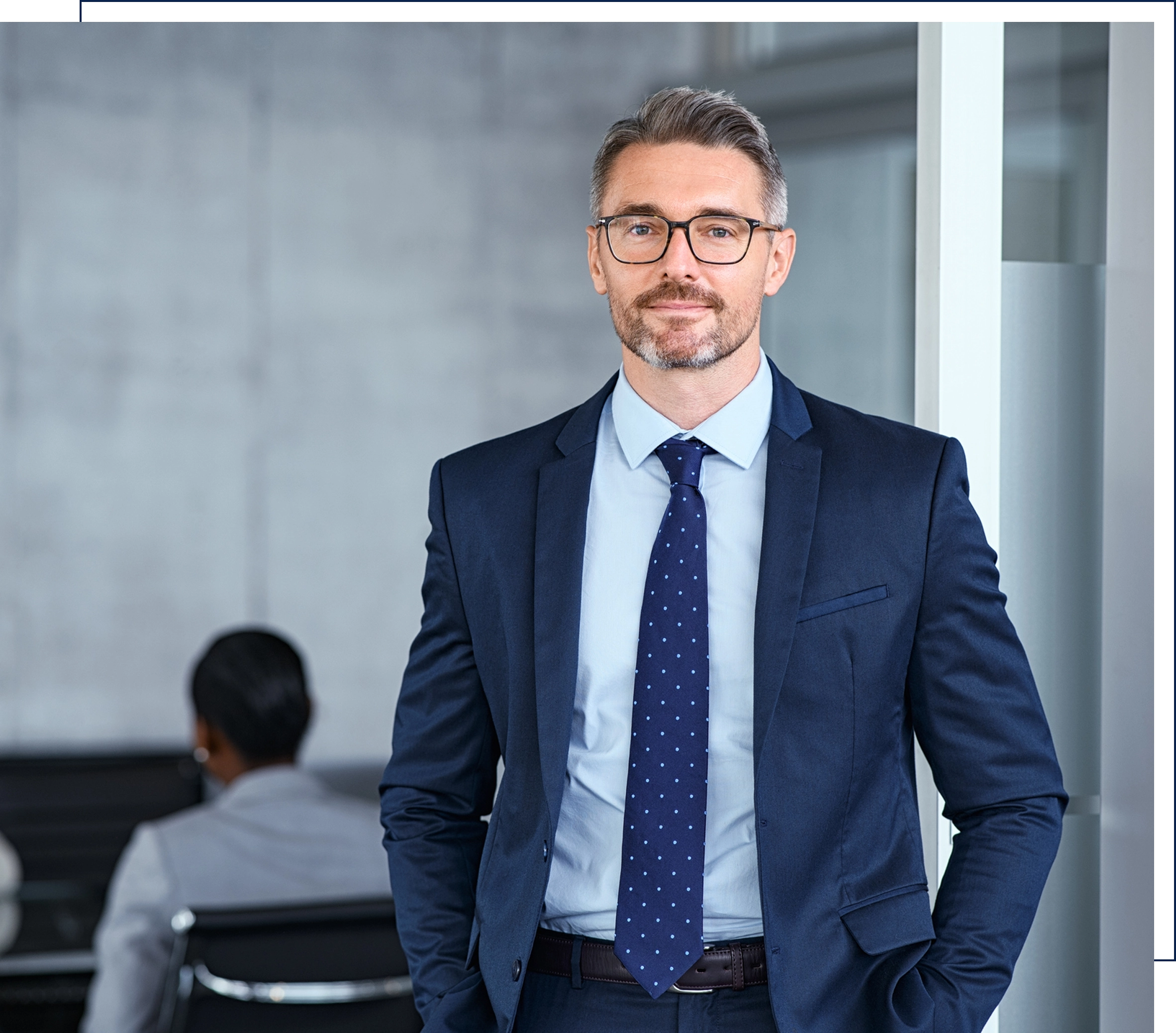 Businessman in suit standing confidently in office.